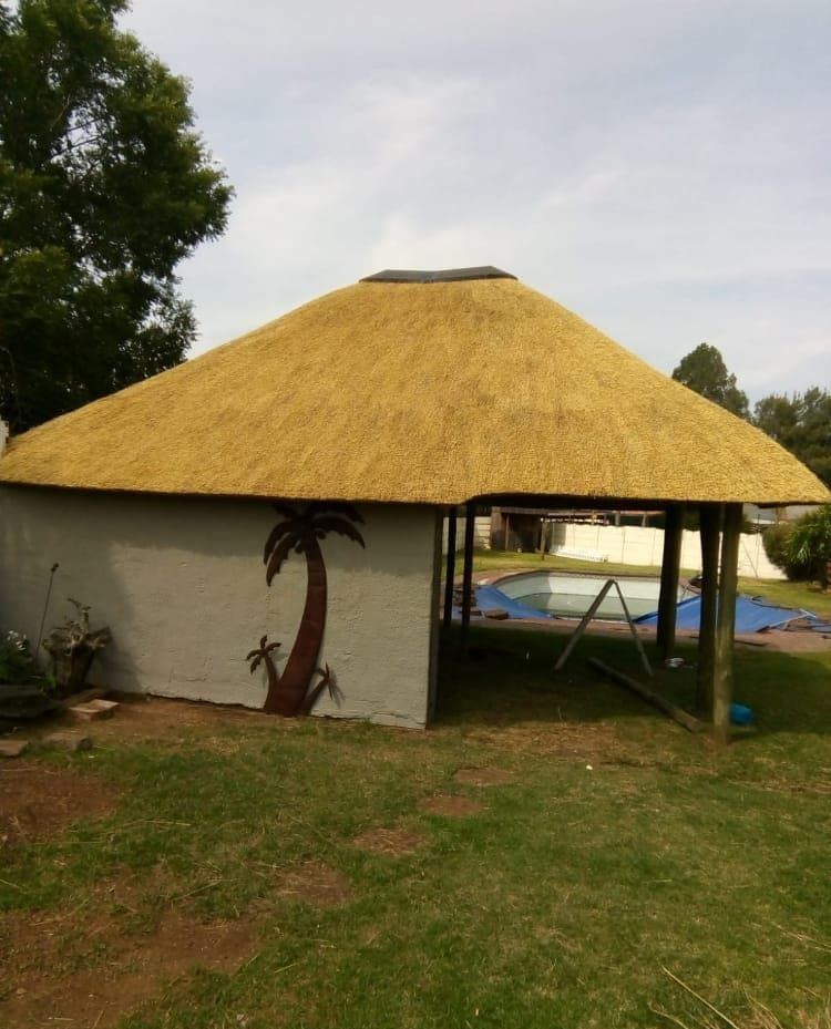 Round thatch lapa beside a pool